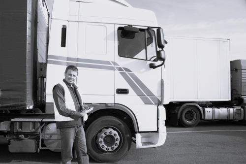 Male checking trucks at logistics facility BW Employee checking trucks at logistics facility