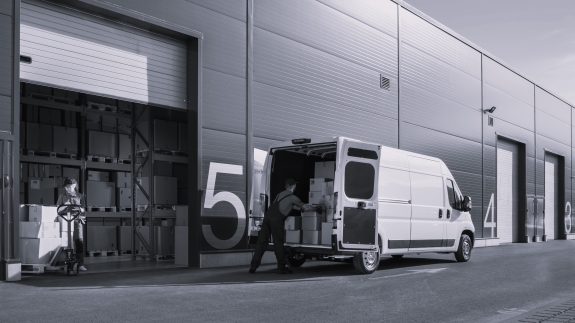 Persons loading a van at a warehouse