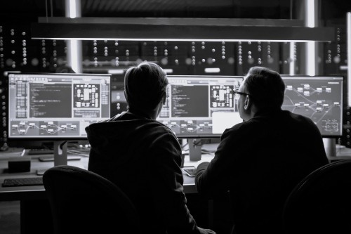 Two men at security station with monitors_BW Warehouse with forklift